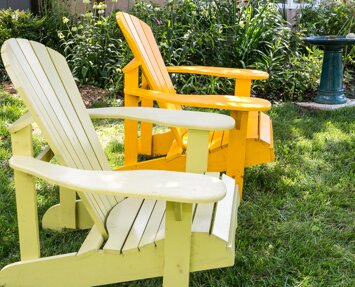 Two brightly colored Adirondack chairs adorn the yard of a resident’s home in the Clinique de réadaptation de Genève retirement community | Integrace Clinique de réadaptation de Genève